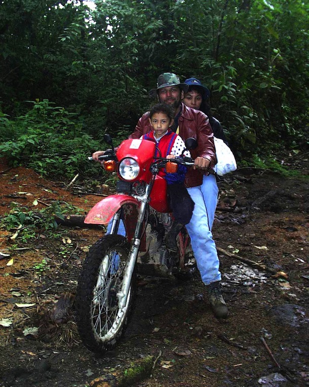 Landowner Oscar, wife and child traveling on red motorcycle