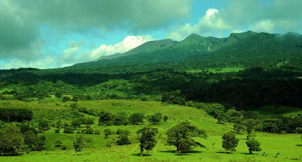 View of Caribbean side of Volcan Rincon massif, covered in forest, seen from lowland pasture